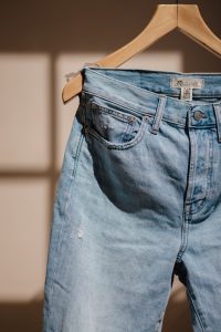 blue denim jeans on brown clothes hanger